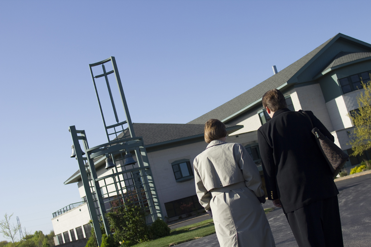 Catholic Sisters Stefanie and Jackie walk toward monastery bell tower